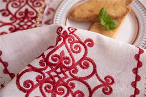 Detail of red baroque floral embroidery on premium off-white linen tablecloth fabric