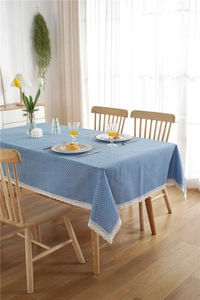 Close-up of blue polka dot tablecloth featuring elegant white lace edges on a wooden table