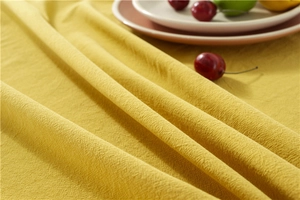 Detailed macro view of yellow washed cotton fabric with natural cross-texture on tablecloth