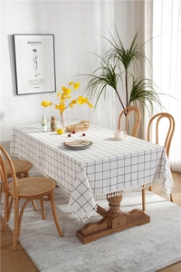 Close-up of minimalist black and white checkered tablecloth with delicate white tassels