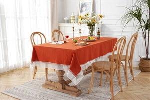 Close-up of bright orange cotton tablecloth with white hollow lace embroidery detail