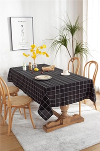 Close-up detail of black and white grid tablecloth with cotton-linen texture on a wood table
