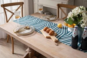 Detailed close-up of blue and grey geometric chenille table runner on a wooden dining table