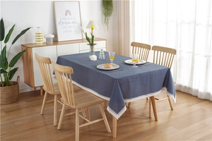 Close-up of dark blue polka dot tablecloth with wide white lace border draping elegantly
