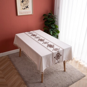 Rectangular cream linen tablecloth with brown floral embroidery and tassel fringe