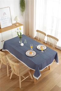 Detail of dark blue polka dot tablecloth featuring elegant white lace edges on wood table
