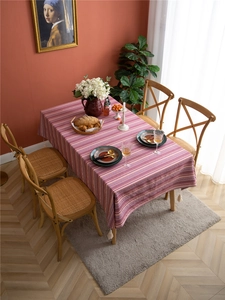 Detail of bohemian floral striped tablecloth featuring white cotton corner tassels