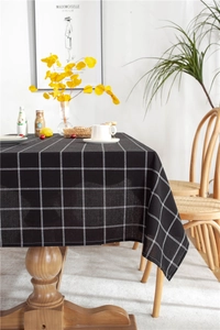 Close-up of black and white checkered tablecloth texture on a modern wooden table
