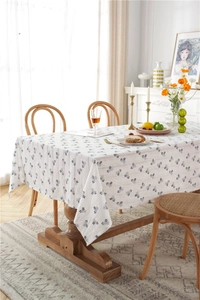 Close-up of rectangular cotton tablecloth with black floral patterns on a wooden table