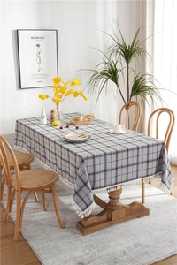 Close-up of grey geometric plaid linen tablecloth with delicate white tassel fringe detail