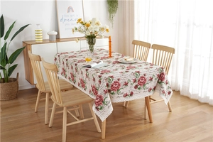 Detailed view of red peony floral pattern and white lace trim on a vintage tablecloth