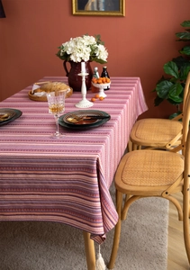Close-up of Bohemian floral striped tablecloth with decorative white tassels and textures