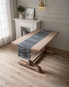 Detail of chenille table runner with black and white chevron pattern and blue bead fringe