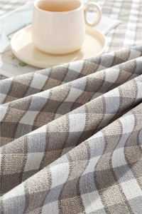 Close-up of checkered polyester tablecloth with tassels and woven fabric texture details