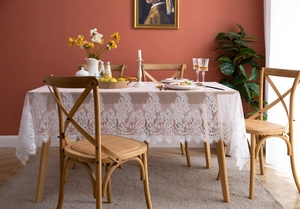 Detail of white eyelash lace tablecloth with floral hollow patterns and scalloped edges