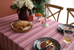 Detail of bohemian woven tablecloth with red and purple stripes and elegant tassels