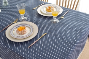 Close-up of navy blue polka dot tablecloth with elegant fringe edge on rectangular table