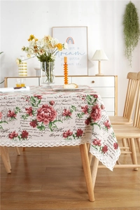 Detailed close-up of retro rose pattern tablecloth with wide white lace border and print