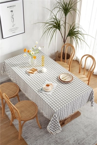 Close-up of grey and white checkered tablecloth featuring elegant white tassel edges