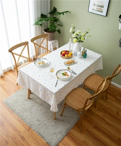 Overhead view of cotton tablecloth with colorful polka dots and white pom-pom fringe edge