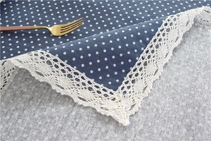 Close-up of deep blue polka dot tablecloth featuring elegant white crochet lace border