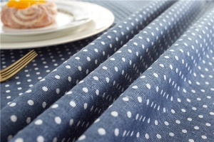 Close-up of navy blue tablecloth with white polka dots and soft fabric texture