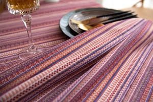 Close-up of Bohemian woven tablecloth featuring colorful geometric stripes and floral patterns