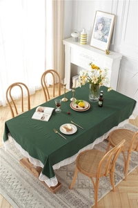 Detail of dark green cotton tablecloth featuring exquisite white floral lace embroidery edge