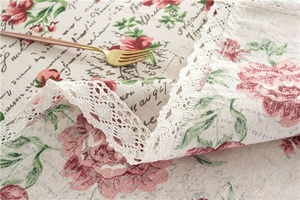 Close-up of pastoral floral tablecloth with lace edges and vintage cotton texture