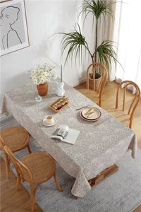 Detailed overhead view of floral pattern tablecloth on a wooden table in a garden setting