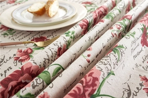 Close-up of vintage rose pattern and French script print on cream cotton lace tablecloth