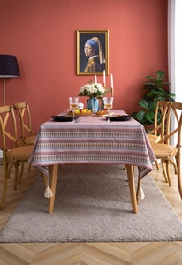 Detail of bohemian woven tablecloth with floral stripes and white corner tassels