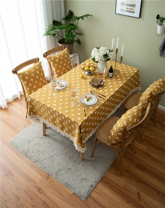 Detailed shot of yellow jacquard tablecloth with diamond patterns and white fringe edges
