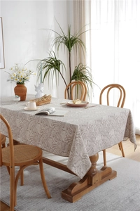 Detail of beige polyester tablecloth featuring white floral pattern and premium stitching
