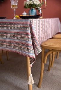 Detail of bohemian floral stripe tablecloth with white tassels and woven texture