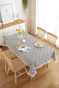 Detailed view of blue floral tablecloth with vintage patterns and white lace edges