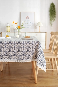 Close-up of blue Damascus pattern tablecloth with white hollow lace edge detail