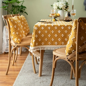 Vintage mustard yellow tablecloth with white tufted floral patterns and elegant fringe trim