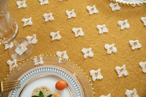 Detailed macro view of yellow jacquard tablecloth with textured tufted geometric patterns