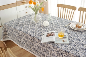 Detailed close-up of vintage blue floral pattern and elegant white lace edge on tablecloth
