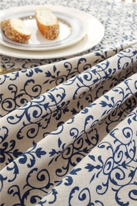 Detailed macro view of beige lace tablecloth with vintage blue floral patterns and soft drape