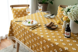 Macro shot of ginger yellow tablecloth with 3D diamond embroidery and white tassels