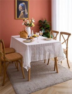 Detail of white lace tablecloth showing intricate floral embroidery and hollow out patterns