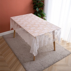 White French lace tablecloth with floral patterns and eyelash fringe on a wooden table