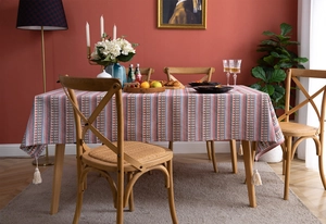 Detail of bohemian striped tablecloth with cotton weave texture and handmade tassels