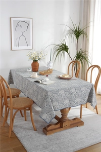 Macro detail of waterproof polyester floral tablecloth with blue floral print and stitched edge