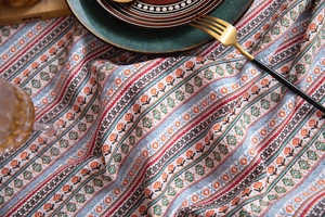 Close-up of Bohemian cotton linen tablecloth with ethnic flower patterns and tassel detail