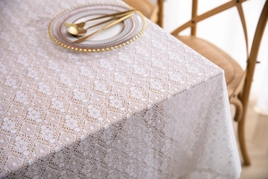 Detailed close-up of French lace tablecloth with intricate floral crochet patterns