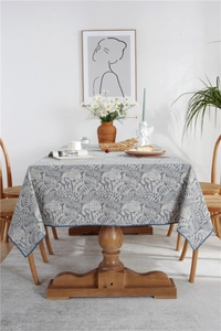 Detail of waterproof tablecloth with blue fern leaf pattern and durable hemmed edges