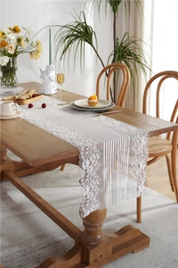 Detail of white French lace table runner with floral embroidery and striped mesh texture